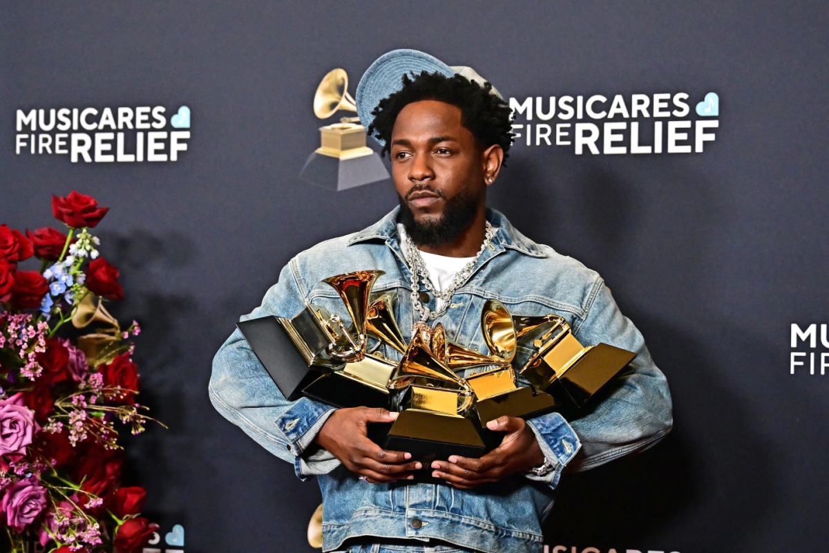 Kendrick Lamar showing off 5 Grammys he won for his hit song "Not like Us". 