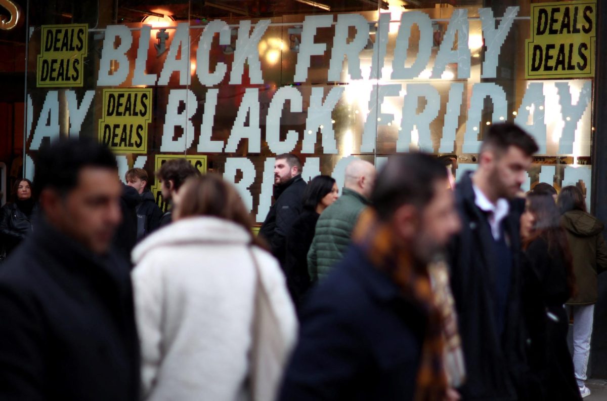 People walk past a shop offering Black Friday deals in Manchester, Britain, November 26, 2022. REUTERS/Phil Noble