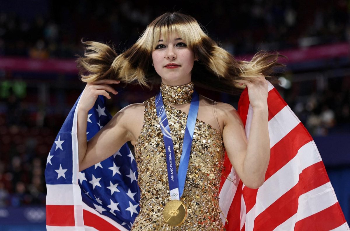 Milano Cortina 2026 Olympics - Figure Skating - Women Single Skating - Victory Ceremony - Milano Ice Skating Arena, Milan, Italy - February 19, 2026. Gold medallist Alysa Liu of United States celebrates with her national flag after winning the Women Single Skating REUTERS/Amanda Perobelli