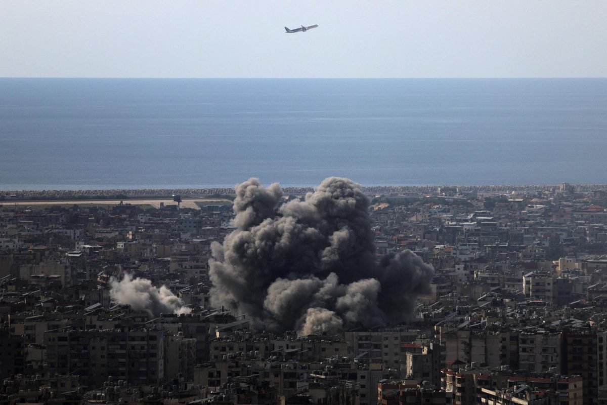 An airplane flies as smoke rises after an Israeli strike on Beirut's southern suburbs, following an escalation between Hezbollah and Israel amid the U.S.-Israeli conflict with Iran, Lebanon, March 6, 2026. REUTERS/Khalil Ashawi